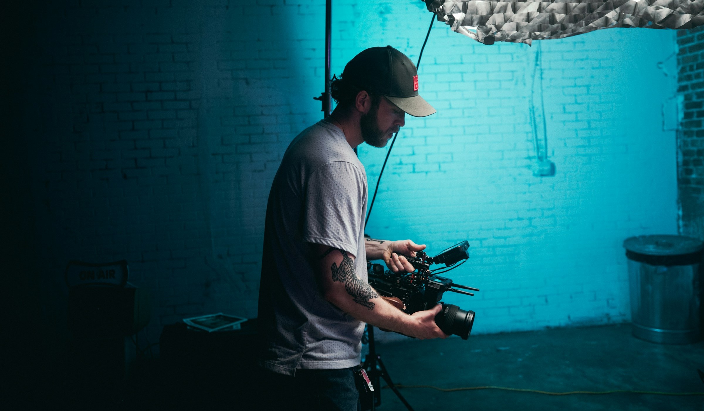 Person holding a camera on a movie set with blue lighting